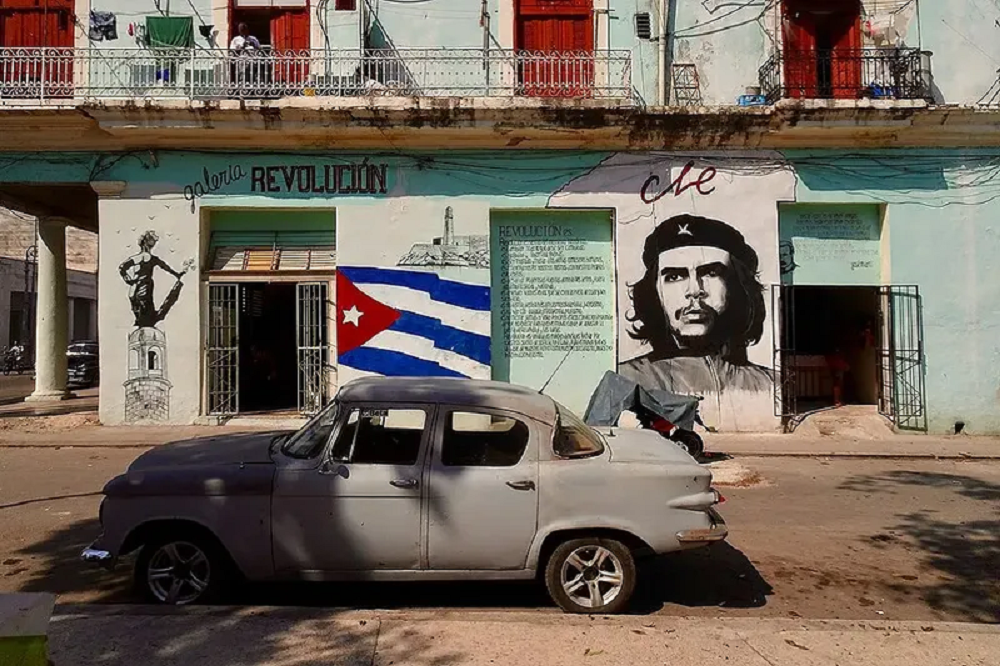 Rua de Cuba com carro antigo estacionado e paredes pintadas