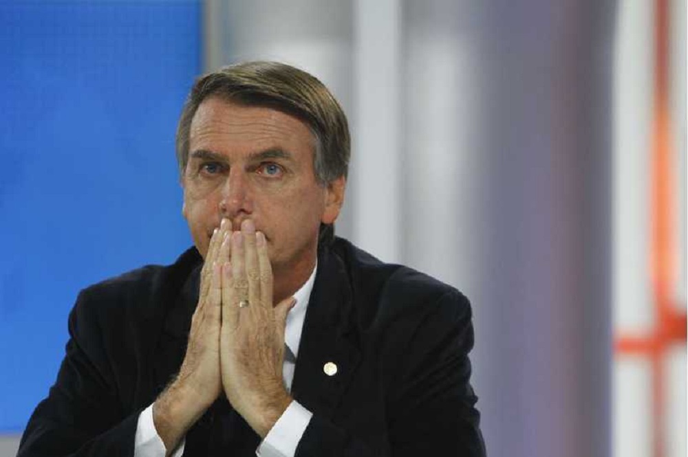 Jair Bolsonaro (PL) com expressão de preocupação e mãos no rosto