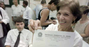 A advogada e ativista Eunice Paiva sorrindo e mostrando papel