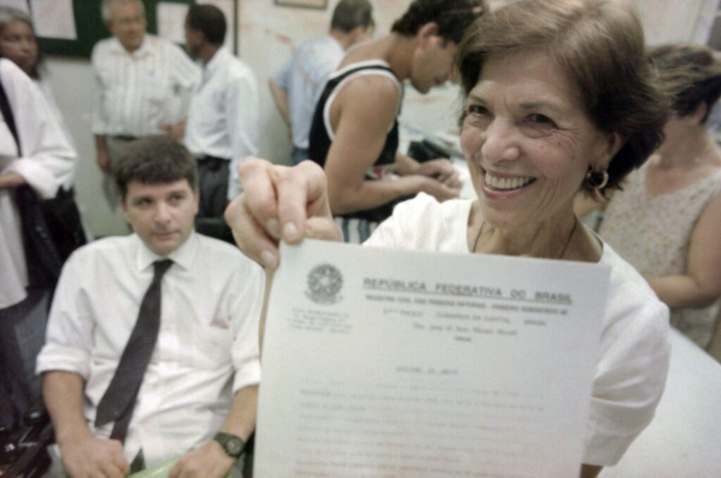 A advogada e ativista Eunice Paiva sorrindo e mostrando papel