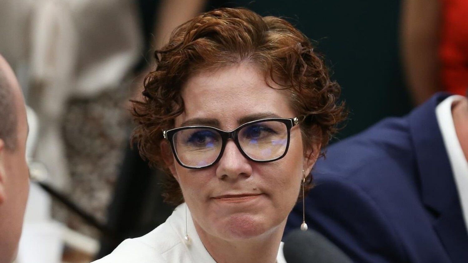 deputada federal Carla Zambelli com expressão de lástima, de óculos, olhando para o lado