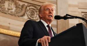 O presidente dos Estados Unidos, Donald Trump, falando em microfone, sério, em foto feita de baixo