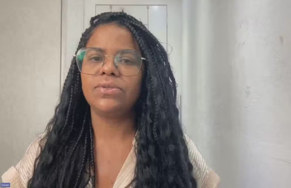 A cozinheira Susan de Sousa Sena de óculos e roupa bege falando para