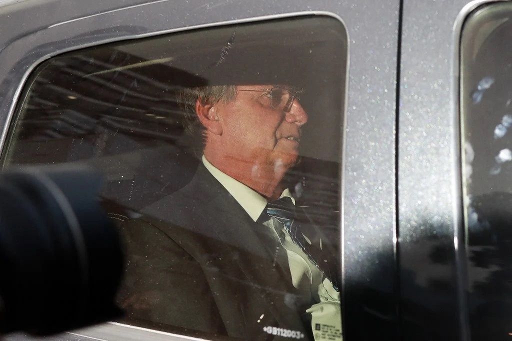 Jair Bolsonaro sério, dentro de carro, de perfil, em foto feita pelo lado de fora