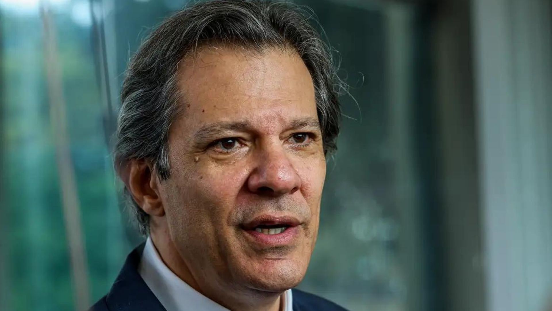 O Ministro da Fazenda, Fernando Haddad, falando, sério, em close