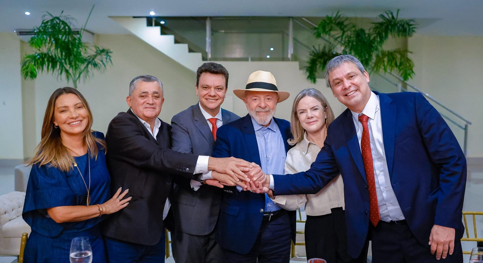 Janja, José Guimarães, Odair Cunha, Lula, Gleisi Hoffmann e Lindbergh Farias posando para foto lado a lado, sorrindo, com mãos unidas