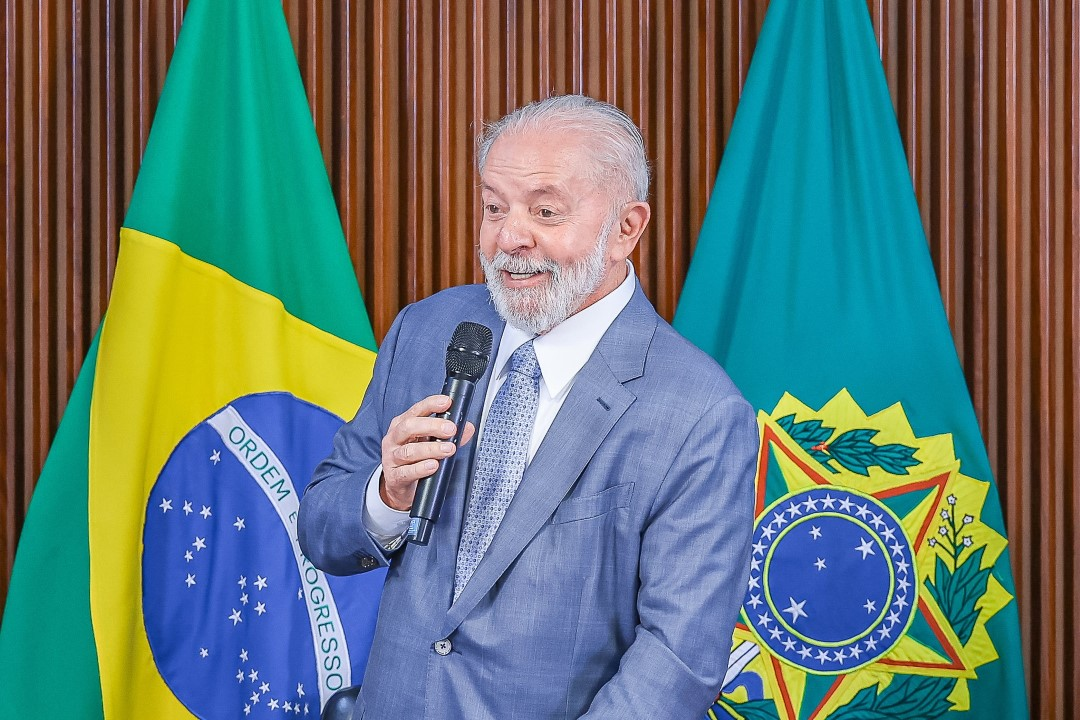 presidente Luiz Inácio Lula da Silva (PT) falando em microfone e sorrindo, olhando para o lado