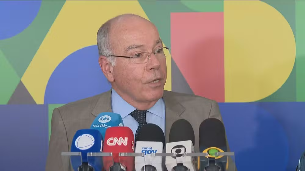 O ministro das Relações Exteriores, Mauro Vieira, falando em microfones, sério, olhando para o lado
