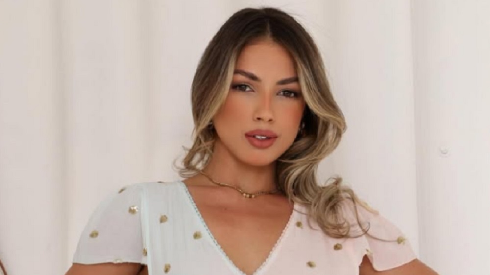 Jackeline Moreira de blusa clara e cabelo solto, fazendo carão para a cãmera