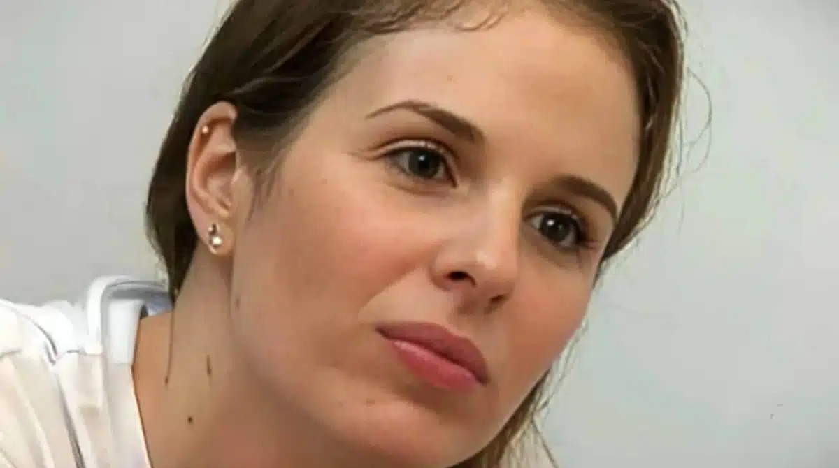 Suzane von Richthofen de roupa clara, em close, séria, sem olhar para a câmera