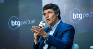 O banqueiro André Esteves, do BTG Pactual, falando em microfone e gesticulando