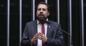 O deputado federal Guilherme Boulos (PSOL) falando e gesticulando, sério, na Câmara dos Deputados