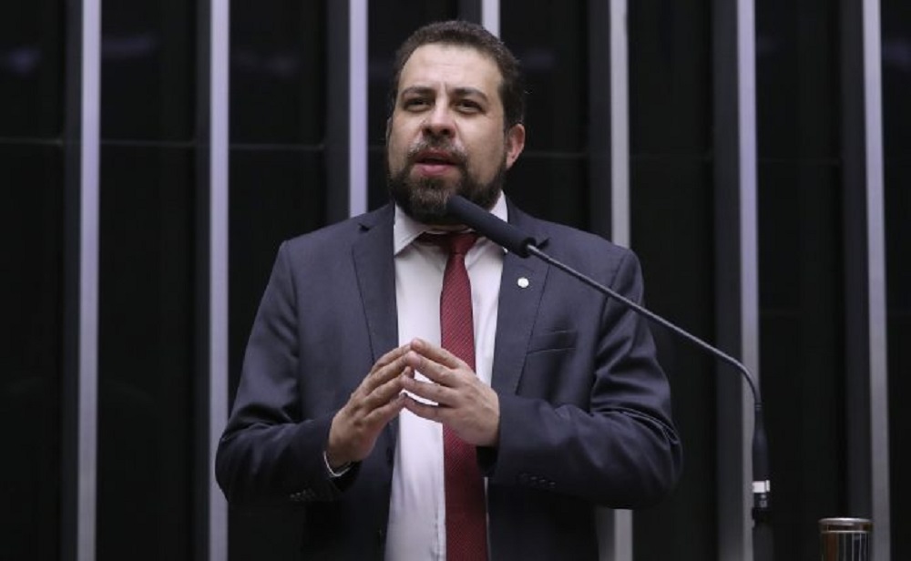 O deputado federal Guilherme Boulos (PSOL) falando e gesticulando, sério, na Câmara dos Deputados