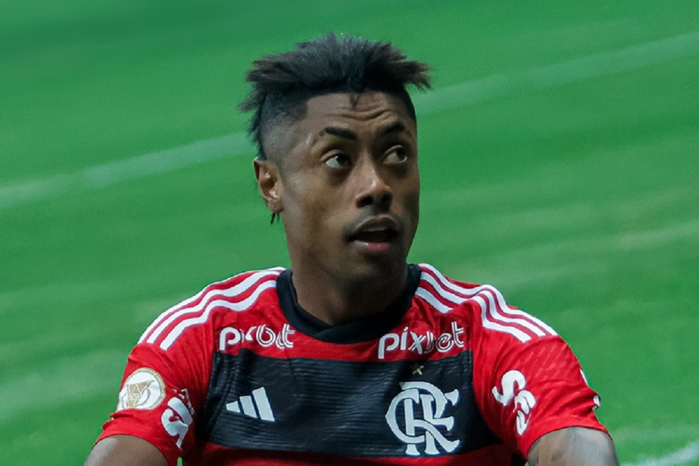 O jogador Bruno Henrique, do Flamengo, em campo, olhando para o lado com expressão de curiosidade