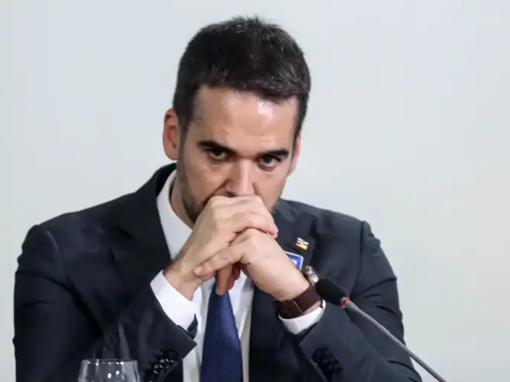 Eduardo Leite sério, com mãos unidas na frente da boca