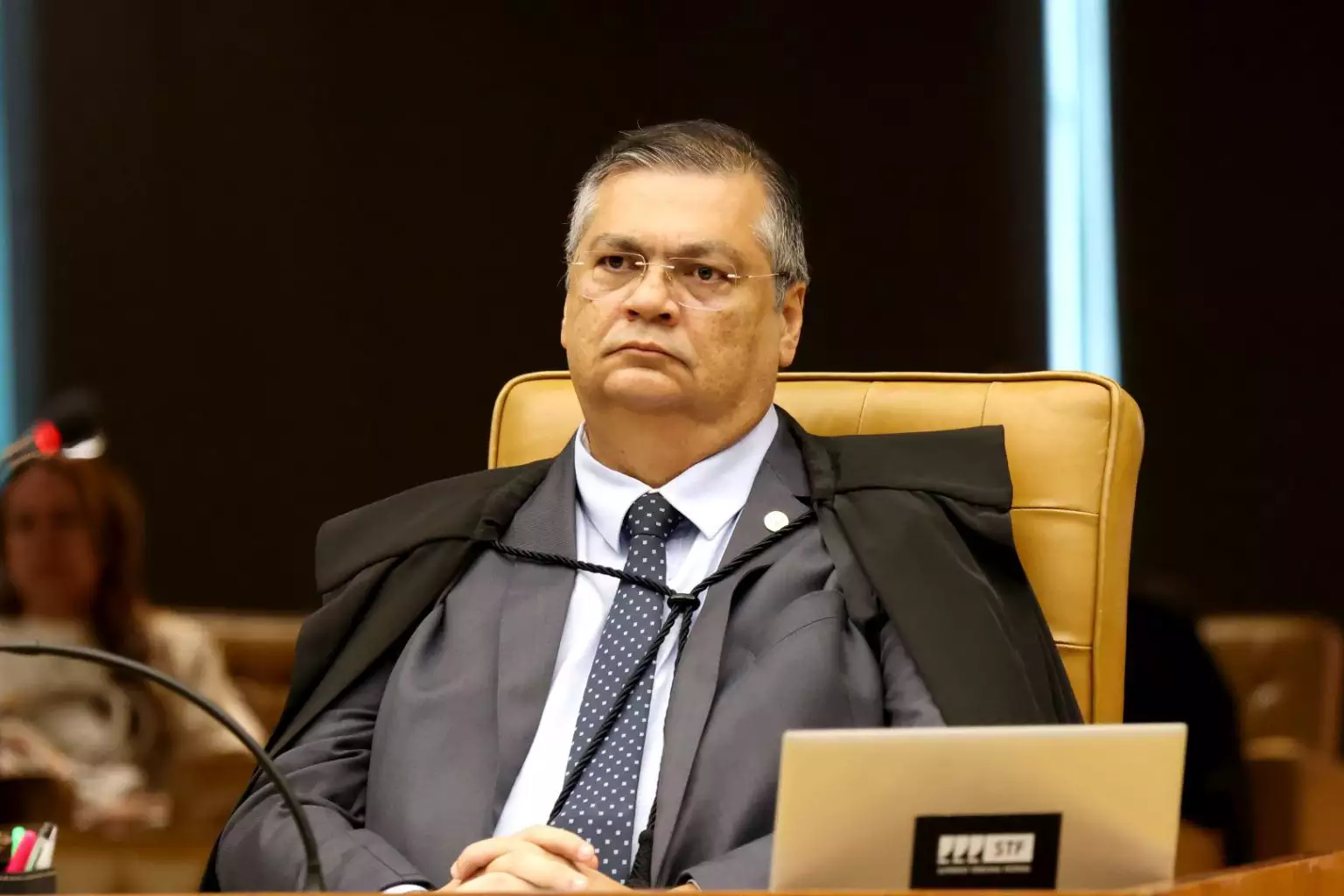 Flávio Dino sério, com expressão pensativa, sem olhar para a câmera