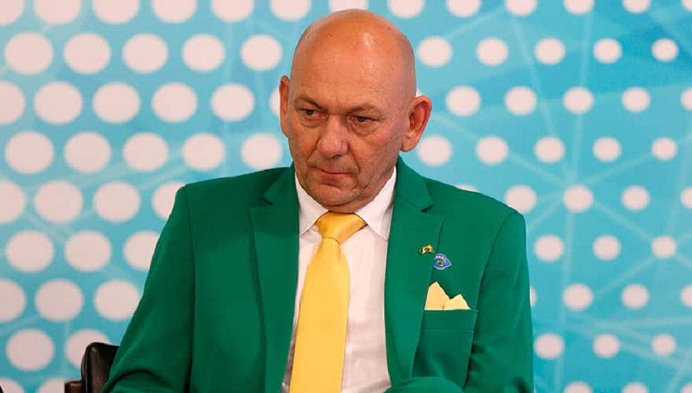 empresário Luciano Hang, dono da rede de lojas Havan, de roupa verde e amarela, cabisbaixo e sério