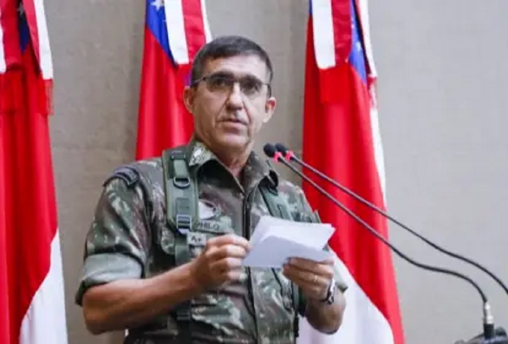 general Estevam Theophilo fardado, falando em microfone, com papel na mão