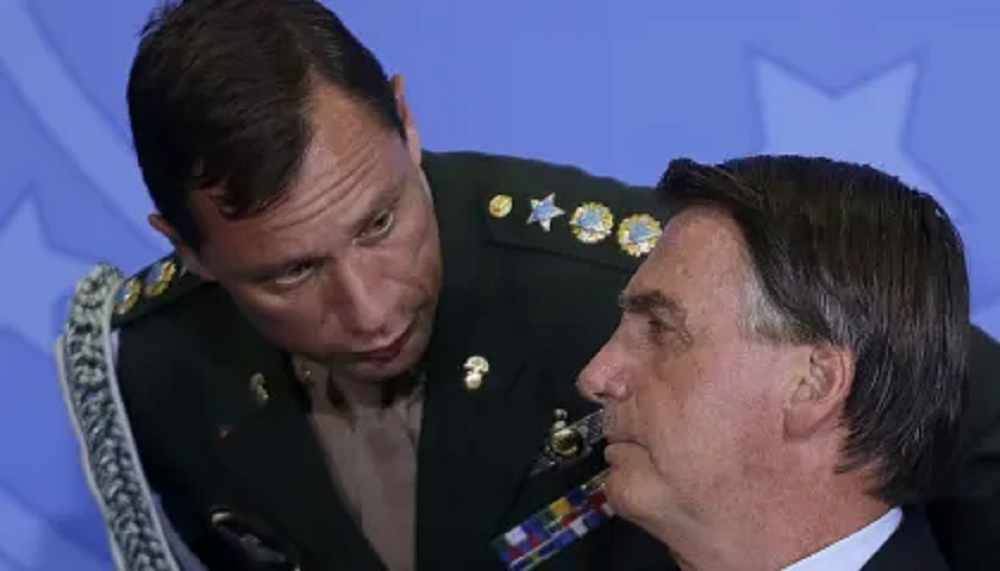 Mauro Cid e Jair Bolsonaro conversando, o militar abaixado, os dois se olhando