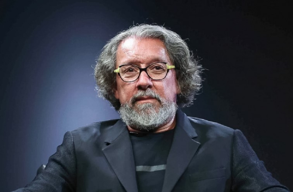 Antônio Carlos de Almeida Castro sério, olhando para a câmera, de óculos