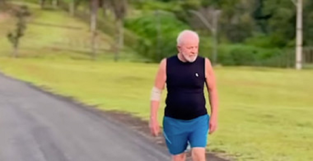 presidente Luiz Inácio Lula da Silva (PT) caminhando com regata preta, bermuda azul e braço enfaixadao