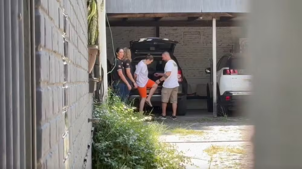 Deise dos Anjos quando foi depor na delegacia de Torres, saindo de carro algemada