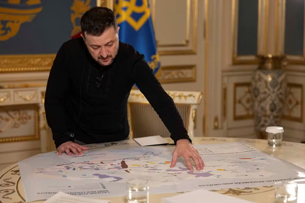Volodymyr Zelensky, presidente da Ucrânia, mostrando mapa com recursos minerais do país a jornalista