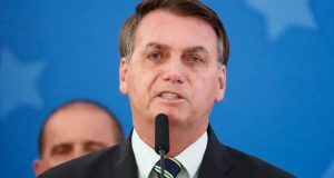 ex-presidente Jair Bolsonaro falando em microfone com cara de choro