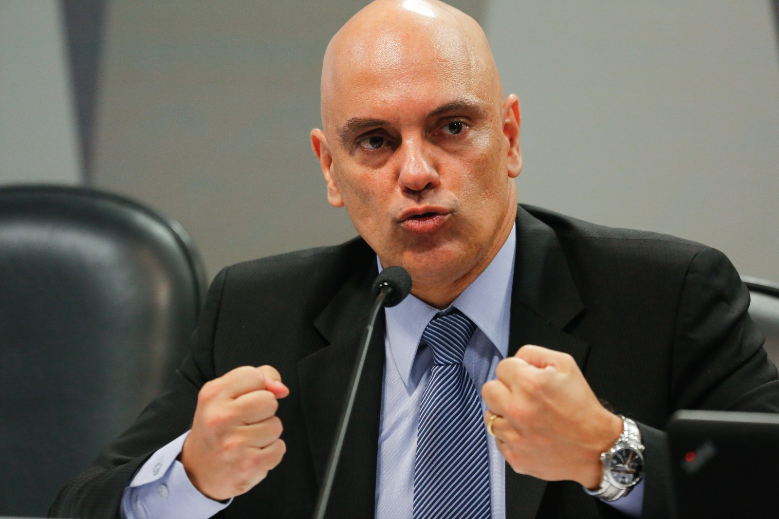 ministro do Supremo Tribunal Federal (STF), Alexandre de Moraes, falando, com os punhos cerrados, sério, sem olhar para a câmera