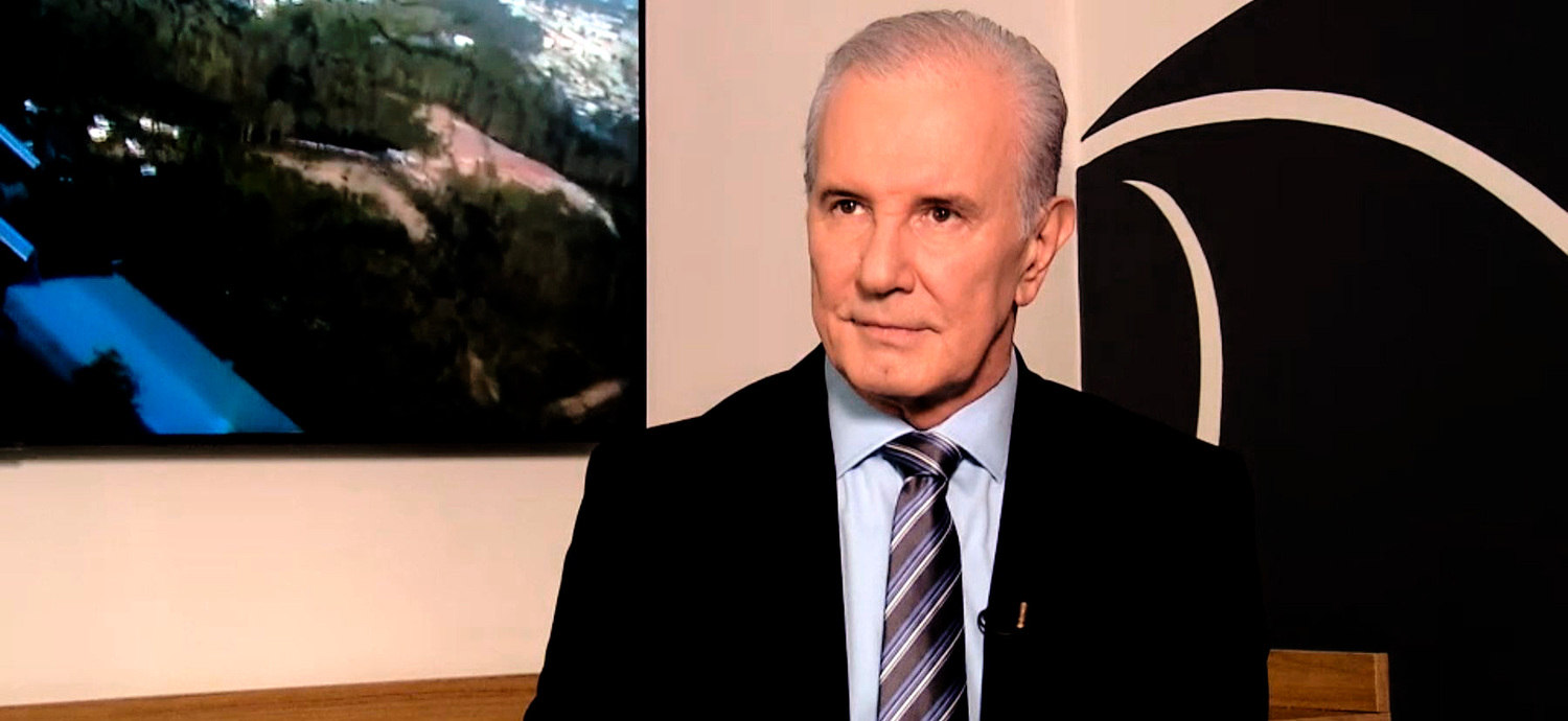 O jornalista Celso Freitas sério, de terno e gravata, olhando para o lado