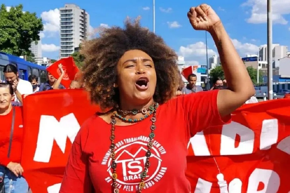 A deputada estadual Ediane Maria (PSOL) falando e gesticulando em passeata, de roupa vermelha