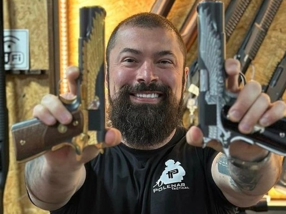 O deputado federal Paulo Bilynskyj (PL) sorrindo e segurando duas armas