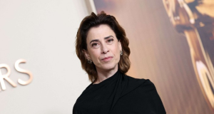 Fernanda Torres de roupa preta, sem sorrir, de cabelo solto