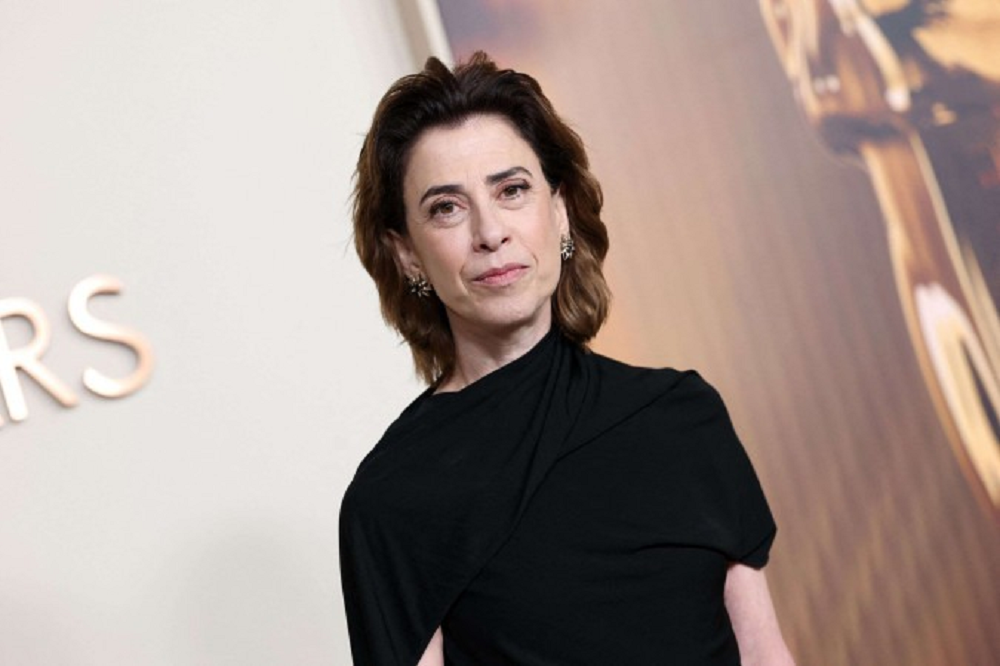 Fernanda Torres de roupa preta, sem sorrir, de cabelo solto