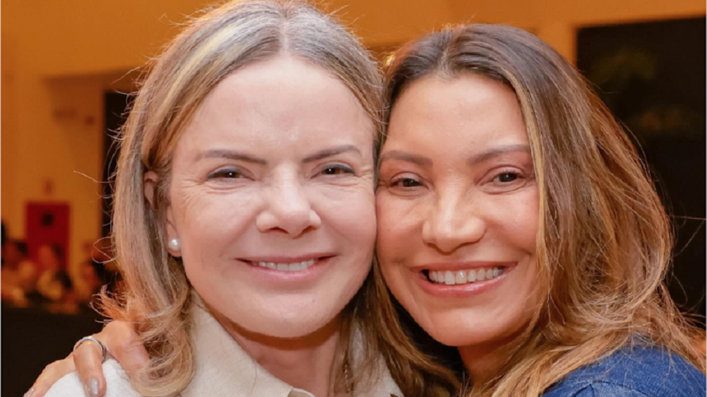 Gleisi Hoffmann e Janja sorrindo lado a lado, em close, olhando para a câmera