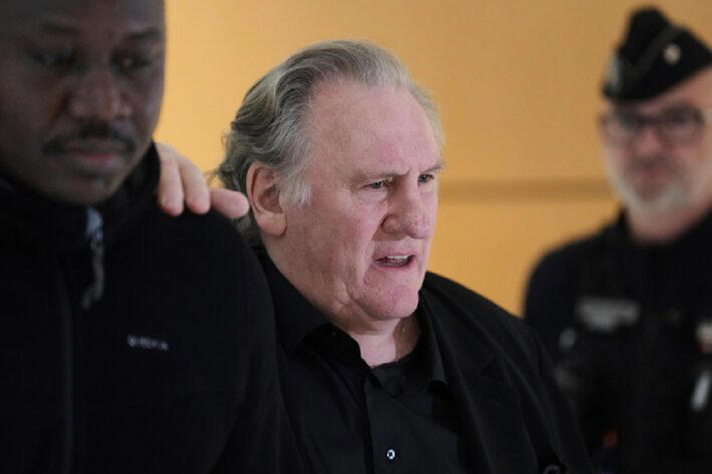 Gérard Depardieu falando, sem olhar pra câmera, de preto