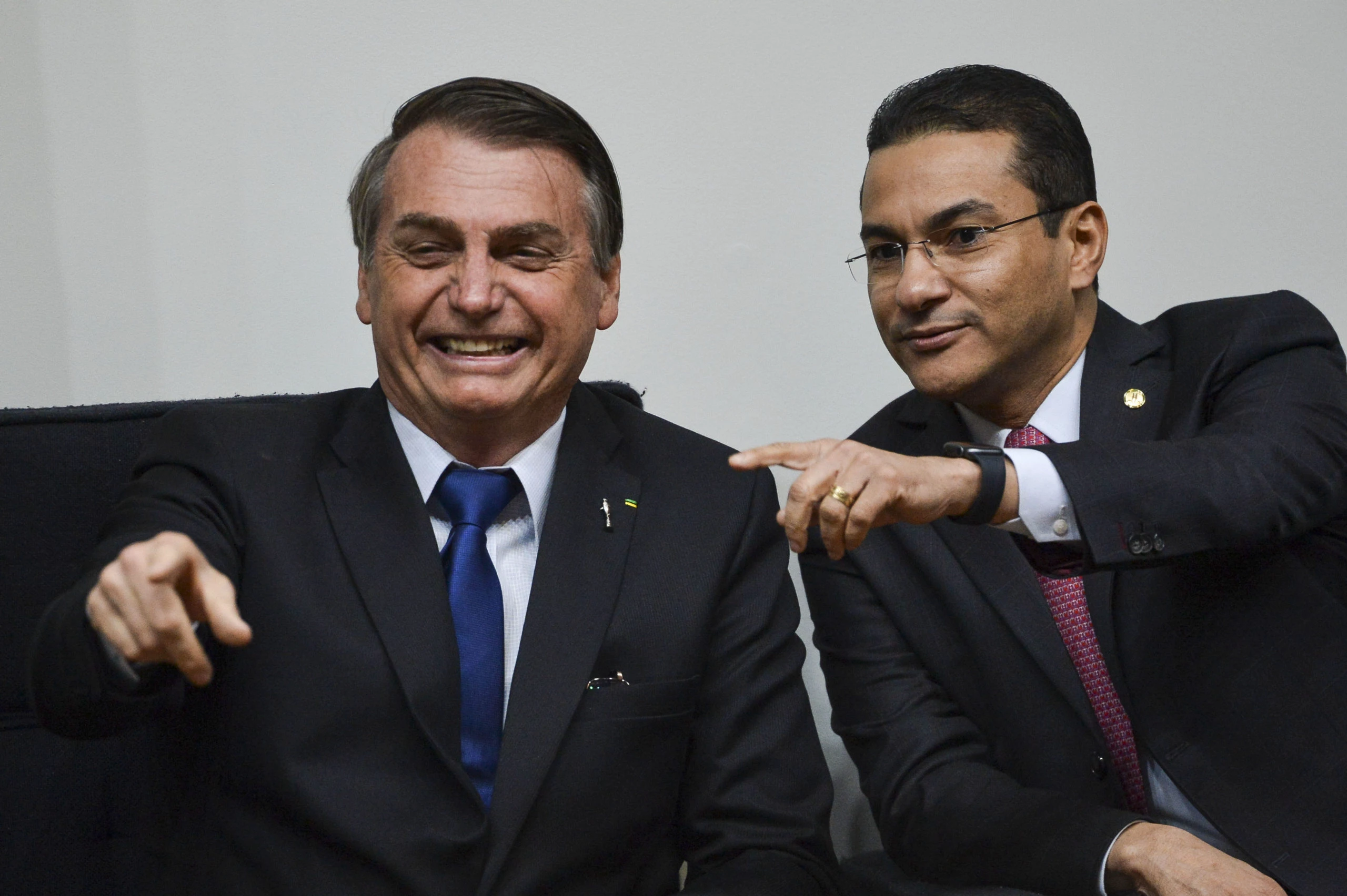 ex-presidente Jair Bolsonaro (PL) e Marcos Pereira sentados lado a lado, apontando pra frente e rindo