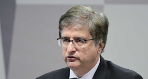 O procurador-geral da República, Paulo Gonet, sério, falando em microfone, sem olhar para a câmera