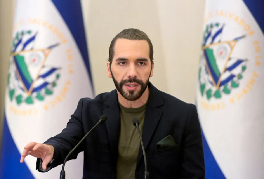 presidente de El Salvador, Nayib Bukele, falando em microfone, sério, de roupa verde e preta