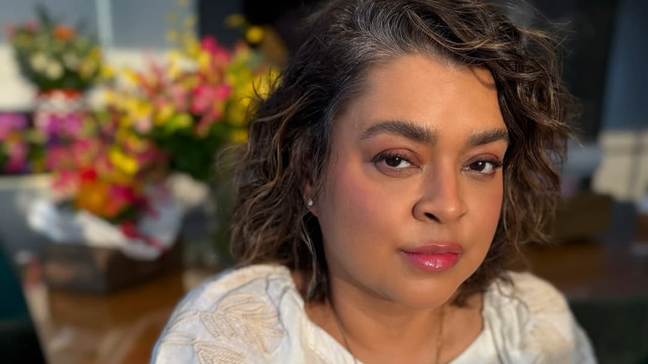 A cantora Preta Gil séria, de roupa branca e cabelo solto, olhando para a câmera, em close