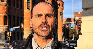 deputado federal licenciado Eduardo Bolsonaro (PL-SP) falando para a câmera, sério, em foto com efeito, em close