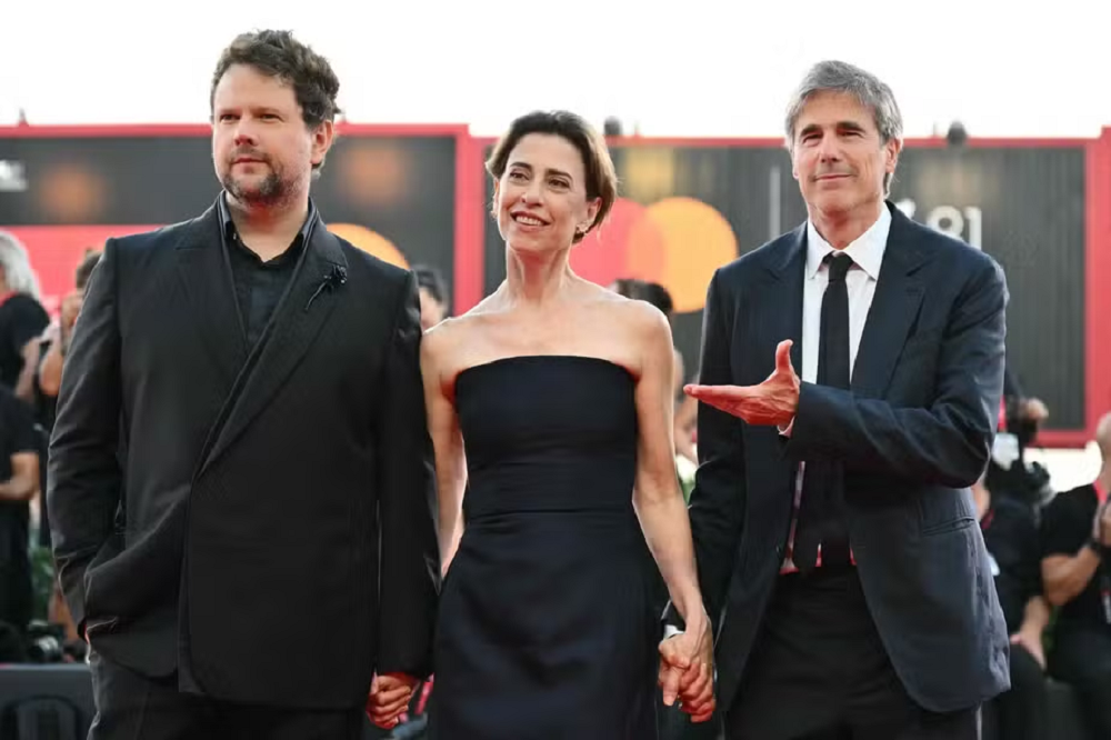 Selton Mello, Fernanda Torres e Walter Salles lado a lado, em pé, de mãos dadas