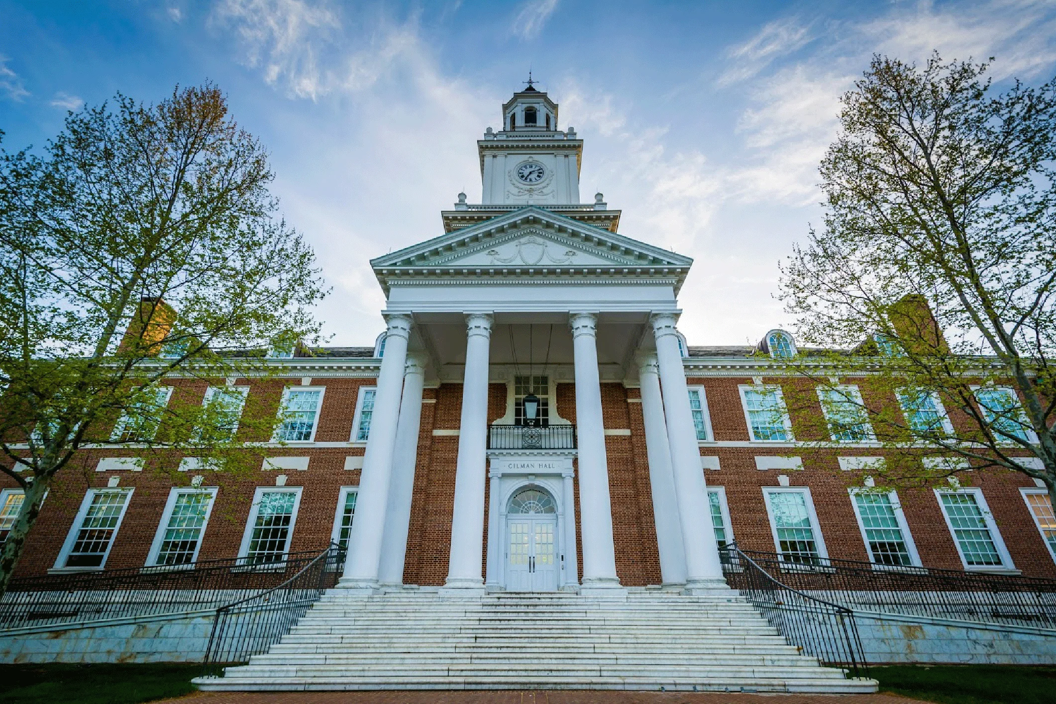 Universidade Johns Hopkins em foto feita em dia de céu azul com nuvens