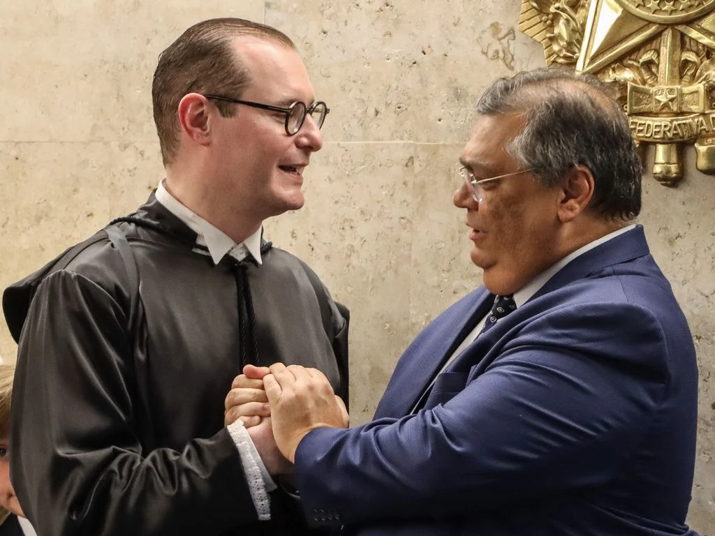 ministros Cristiano Zanin e Flávio Dino, do Supremo Tribunal Federal (STF) sorrindo e se cumprimentando