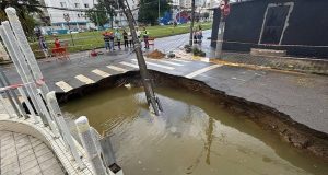 Em São Vicente, o asfalto cedeu na Avenida Marechal Deodoro com Rua Pero Lopes de Souza neste sábado (19), devido às fortes chuvas na região - Reprodução/Defesa Civil