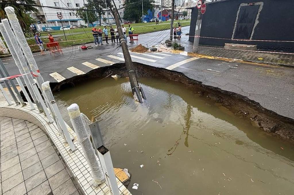 Em São Vicente, o asfalto cedeu na Avenida Marechal Deodoro com Rua Pero Lopes de Souza neste sábado (19), devido às fortes chuvas na região - Reprodução/Defesa Civil