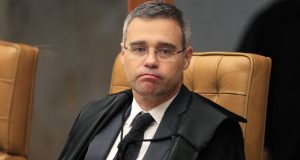 O ministro André Mendonça, do Supremo Tribunal Federal (STF), com expressão de tédio, de óculos, de terno e gravata