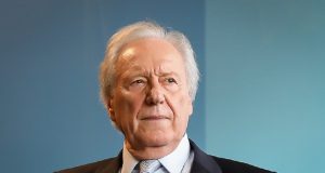 ministro da Justiça e Segurança Pública, Ricardo Lewandowski, olhando para o lado com expressão séria, em fundo azul