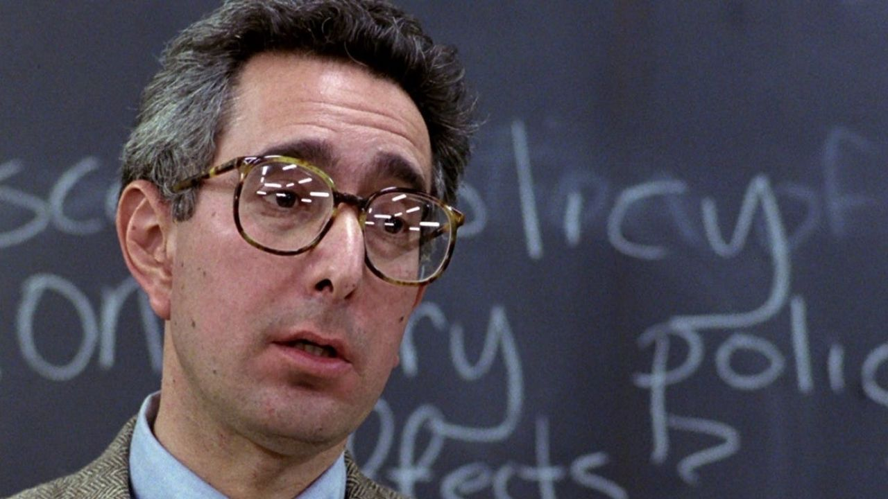 Professor do filme Curtindo a Vida Adoidado falando, de óculos, sem olhar para a câmera