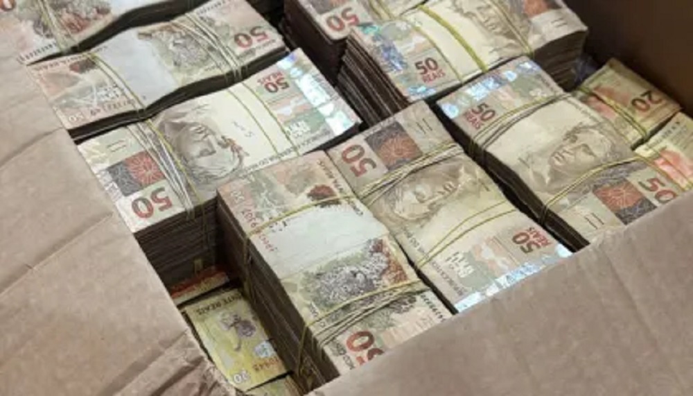 Cédulas de reais em grande quantidade, em caixa de papelão, as de 50 reais por cima
